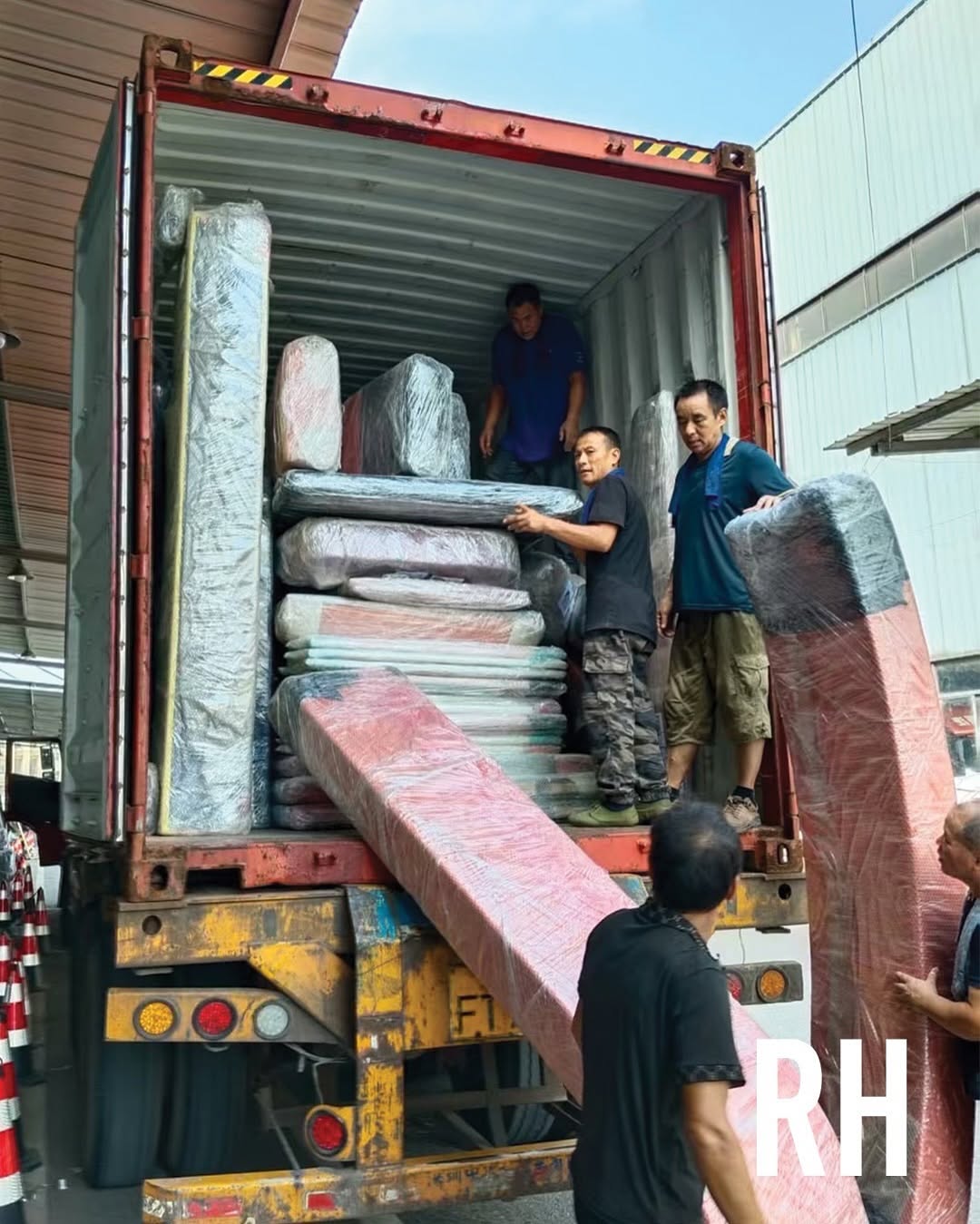 Team handling wrapped items inside a shipping container