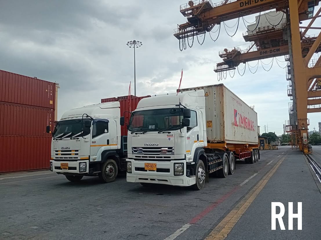 Two container trucks alongside cranes at a container terminal